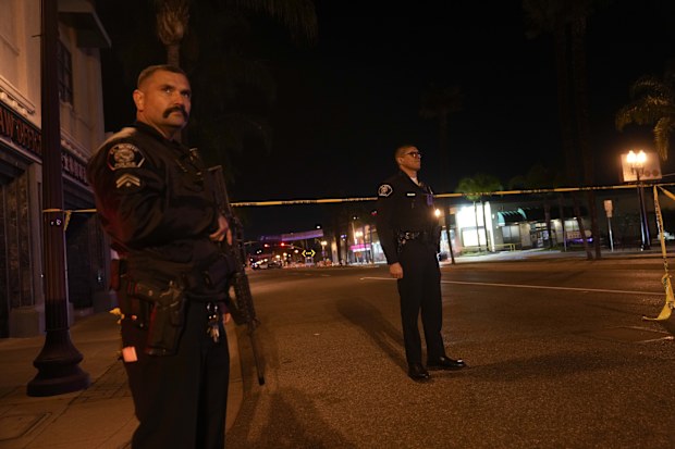 Two police officers stand guard near a scene where a shooting took place in Monterey Park.