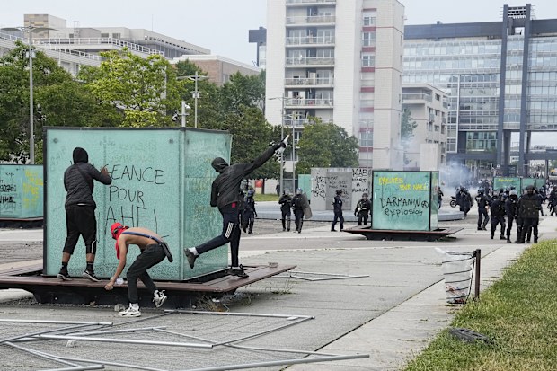 Youth throws a bottle to police forces during riots Thursday, June 29, 2023 in Nanterre, outside Paris. 