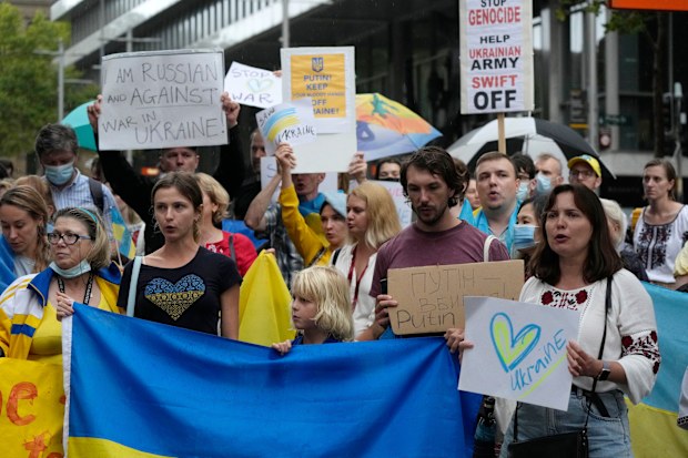 People chant, carry placards and wave Ukrainian flags as they gather in Sydney, Thursday, Feb. 24, 2022, to demonstrate against the attacks in Ukraine. (AP Photo/Rick Rycroft)