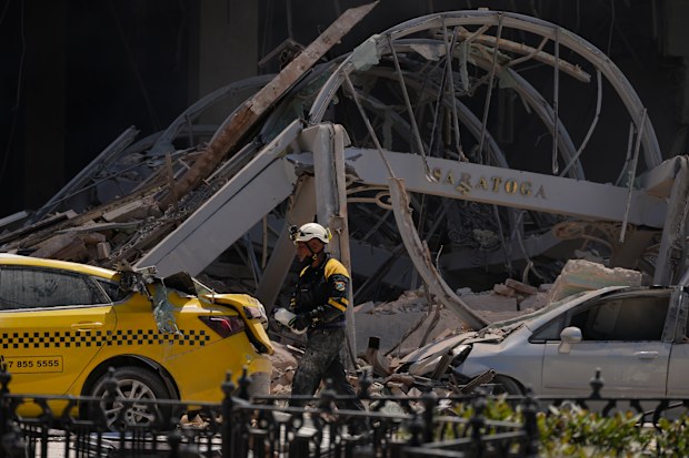 A sign for the five-star Hotel Saratoga hangs amid the rubble after it was heavily damaged by a deadly explosion in Old Havana, Cuba, Friday, May 6, 2022 