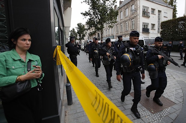 Riot police officers patrol the area after a man armed with a knife killed a teacher and wounded two others at a high school in northern France, Friday, Oct. 13, 2023 in Arras. 