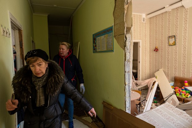Women walks inside a school damaged among other residential buildings following a bombing in Kyiv, Ukraine, Friday, March 18, 2022. 