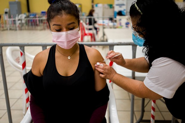 A healthcare worker administers a booster dose of a COVID 19 vaccine at a temporary vaccine centre in Guatemala City, Tuesday , March 1, 2022