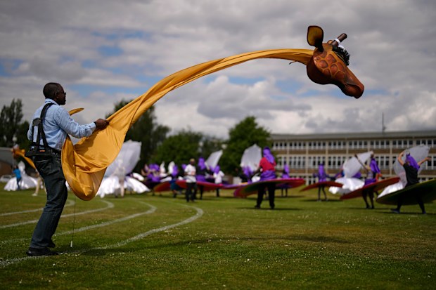 A member of the Mahogany carnival group with a giraffe costume takes part in a rehearsal for their upcoming performance at the Platinum Jubilee Pageant, at Queens Park Community School, in north London, Saturday, May 28, 2022.  