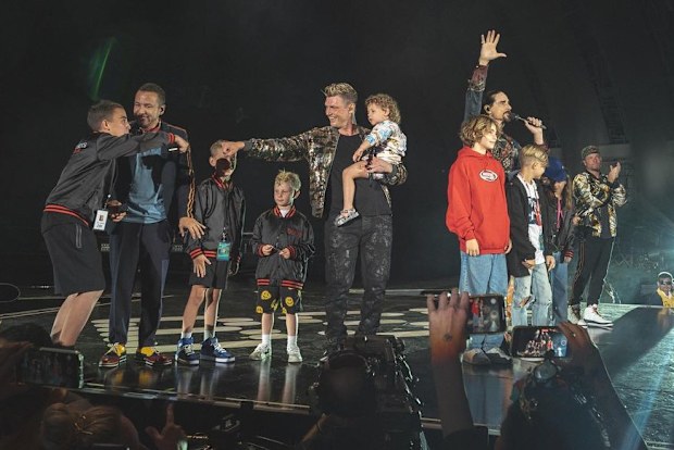Backstreet Boys perform on stage with fans. 