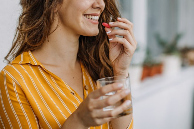 Young adult woman taking supplements.