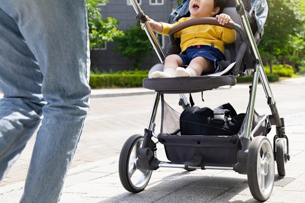 A mother taking a walk with her baby in a stroller in an apartment complex in Korea