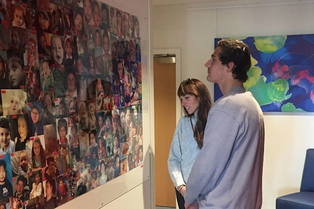 Karen shows AFL star and Rio's Legacy ambassador Billy Smith the wall of photos at Bear Cottage.