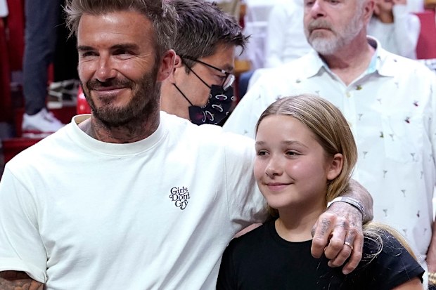 David Beckham stands with his daughter Harper Seven Beckham during the first half of Game 2 of an NBA basketball first-round playoff series between the Miami Heat and Atlanta Hawks, Tuesday, April 19, 2022, in Miami. (AP Photo/Lynne Sladky)