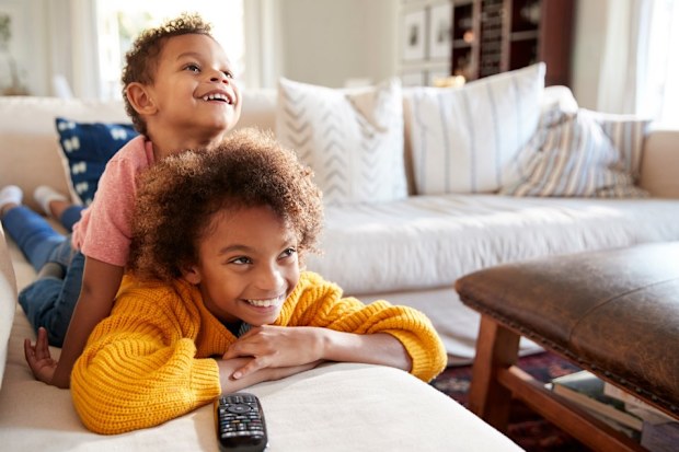 Two kids watching tv. 