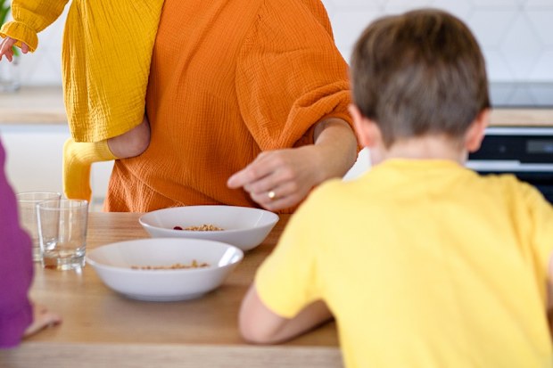 Woman giving children breakfast