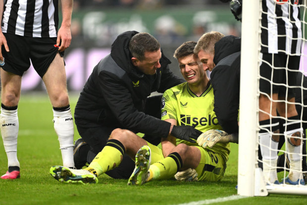 Newcastle United goalkeeper Nick Pope receives treatment for a shoulder injury which forces him to leave the field.