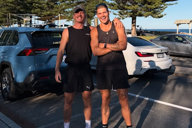 William Goodge (right) and runner Ned Brockman pose at Cottesloe Beach in Western Australia.