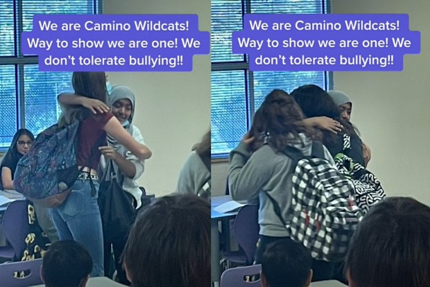 Young teenagers in school embracing and hugging in a classroom.