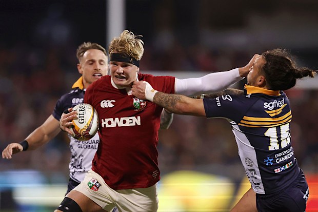 Henry Pollock of British & Irish Lions is tackled by Andy Muirhead of the ACT Brumbies.