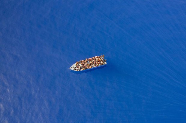 A group thought to be migrants from Tunisia on board a precarious wooden boat heads for the Italian coast.