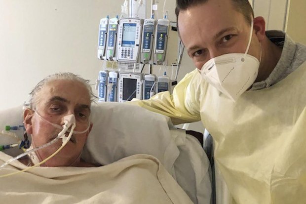 David Bennett Jr., right, stands next to his father's hospital bed in Baltimore.