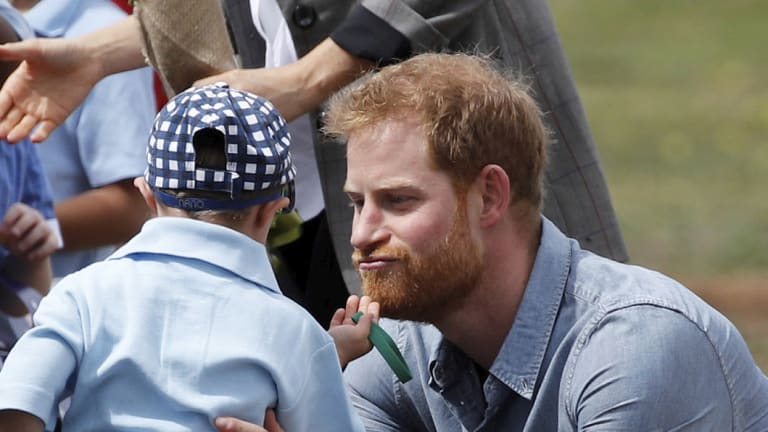 Prince Harry is tickled by Luke Vincent, 5, on his arrival in Dubbo, Australia.