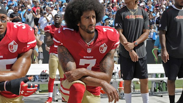 Colin Kaepernick kneels during the national anthem. (AAP)