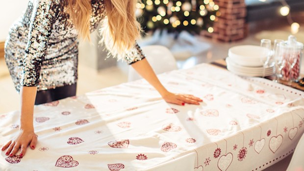 Woman arranging table for Christmas dinner. 