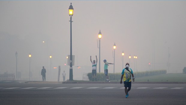 Morning walkers exercise amidst smog due to firecrackers burnt in Thursday's Diwali festival, in New Delhi, India. (AP)
