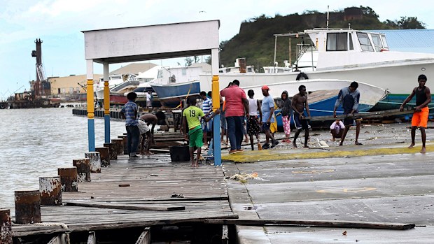 People recover broken parts of the dock after the passing of Hurricane Irma, in St. John's. (AAP)