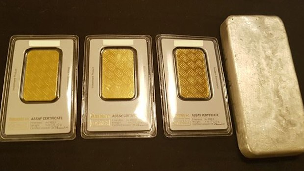 Police seized three gold ingots weighing an ounce each, one kilogram of silver, two cars and more than $80,000 cash. (SA Police)