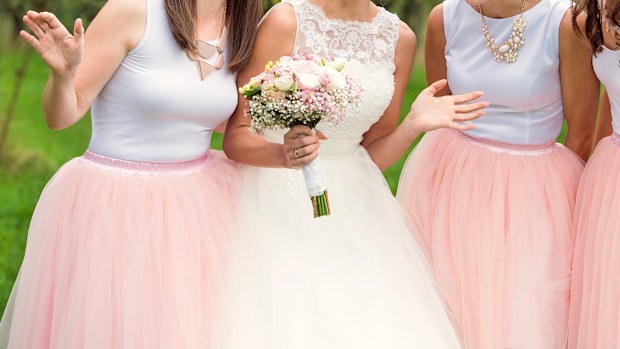 Beautiful young bride with her bridesmaids outside in nature