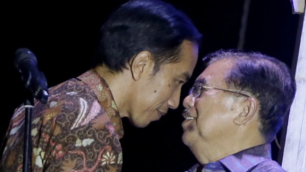 Indonesian president-elect Joko Widodo congratulates his running mate Jusuf Kalla. (AAP)