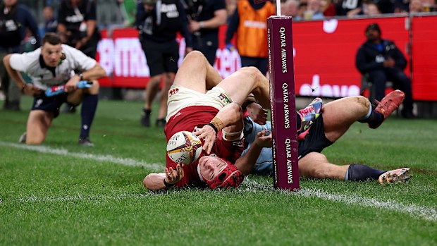 Josh van der Flier of the Lions is tackled and driven into touch by Tom Lambert.