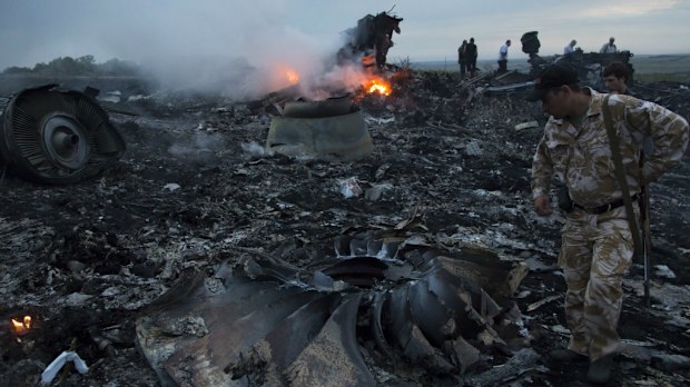 People walk amongst the debris at the crash site of a passenger plane near the village of Grabovo, Ukraine, Thursday, July 17, 2014. (AAP)