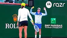 Iga Swiatek hits ball towards ball kid.