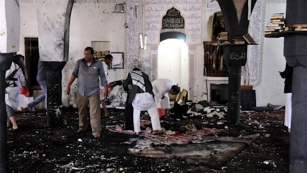Members of Houthi militia inspect the scene of a suicide attack targeting the al-Hashahush mosque in Sana’a, Yemen. (AAP)