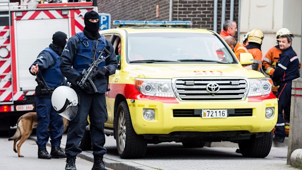 Armed police guard a street in the Brussels neighbourhood of Molenbeek, amid a manhunt for a suspect of the Paris attacks. (AAP)