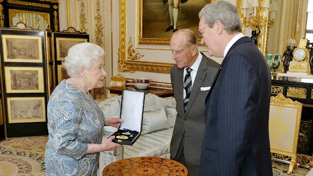 Queen Elizabeth talks with the Australian High Commissioner Alexander Downer as she prepares to present Britain's Prince Philip with the Insignia of a Knight of the Order of Australia. (AAP)