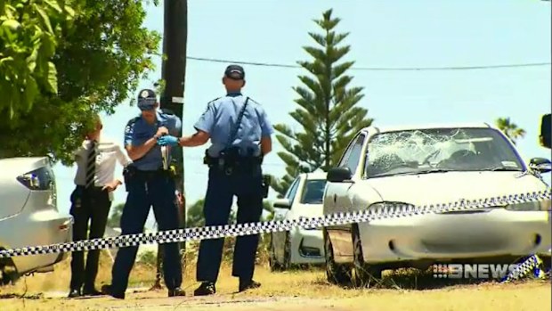 Police examine a damaged car outside the Morley home. (9NEWS)