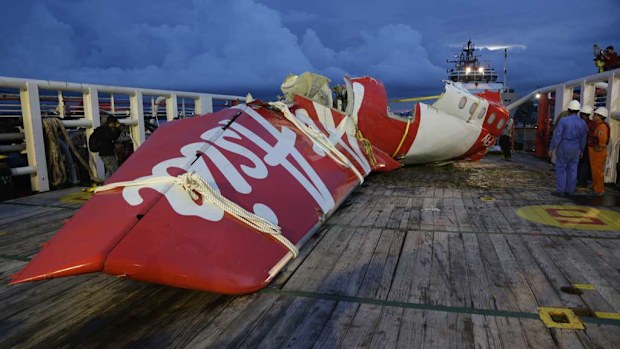 Crew members of Crest Onyx prepare to unload parts of AirAsia Flight 8501 from the ship at Kumai port in Pangkalan Bun. (AAP)