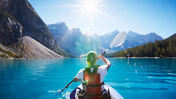Kayaking the glacial waters of Moraine Lake, Banff National Park, Canada.