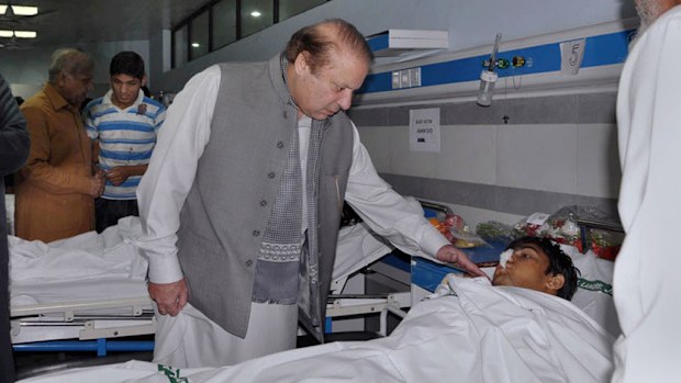 Pakistan's Prime Minister Nawaz Sharif talks to an injured victim of Sunday's suicide bombing during his visit to a local hospital in Lahore. (AP)