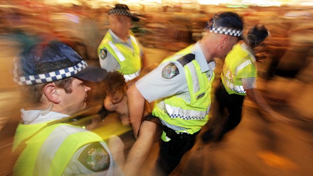 Queensland Police officers take a young person into custody. (AAP Image/Dean Saffron) 