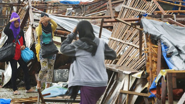 Residents salvage daily necessities and keepsakes from houses destroyed by strong winds brought by powerful typhoon Hagupit. (AAP)