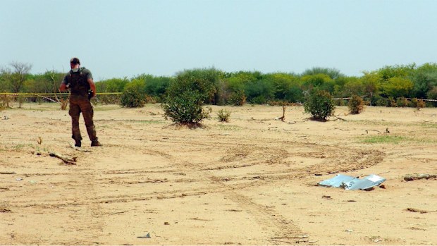A soldier guards the AH5017 crash site. No intact bodies have been found yet of any of the 118 on board. (AAP)