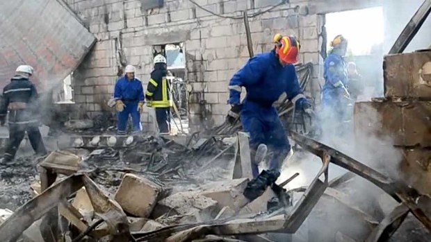 Emergency services search the site of the fire. (AP)