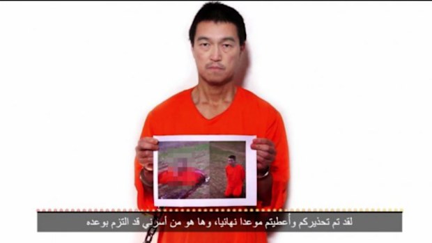 Japanese hostage Kenji Goto holds up a photo of a Jordanian pilot in a new video. (Supplied)