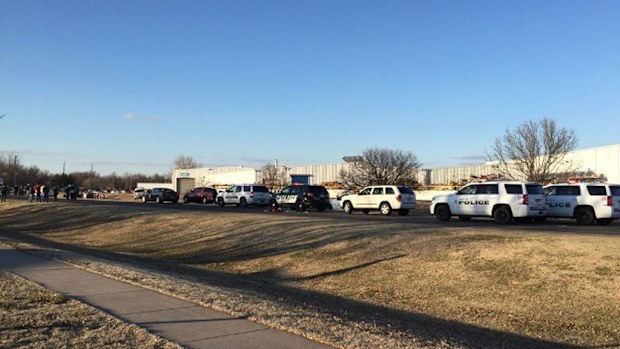 Police vehicles line the road after a shooting at an industrial site in Hesston. (Image: KWCH-TV /AAP)