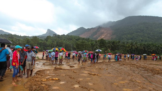 Landslide survivors walk through the mud after a landslide in the Kegalle district of Sri Lanka. (AFP)