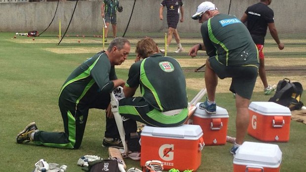 Shane Watson with a team doctor after being struck on the helmet in the nets. (Twitter)