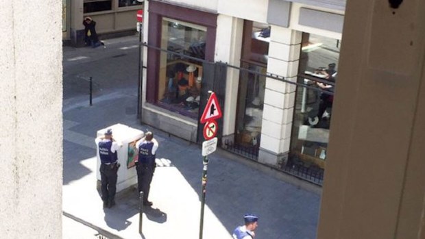 Police surround the suspect who was wearing a long coat with wires showing. (Twitter)