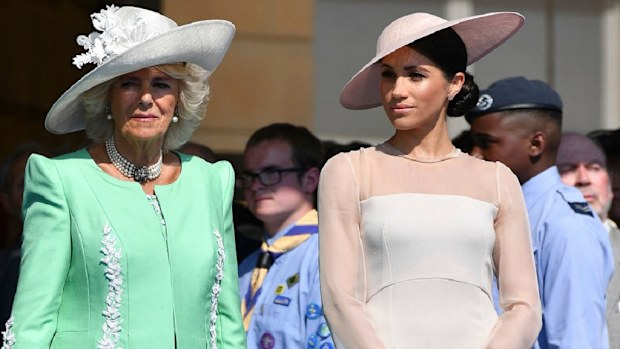 Meghan stands with Camilla during a garden party at Buckingham Palace in London, Tuesday May 22, 2018.
