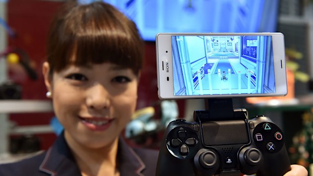 A Sony employee displays the new smartphone Xperia Z3 with a PlayStation4 video game controller at the company's headquarters in Tokyo earlier this month. (Getty Images)